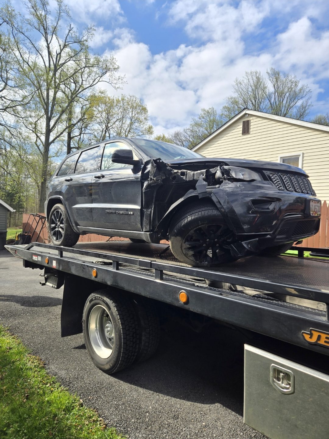 BML Towing flatbed tow truck hauling a damaged Jeep in Baltimore, Maryland